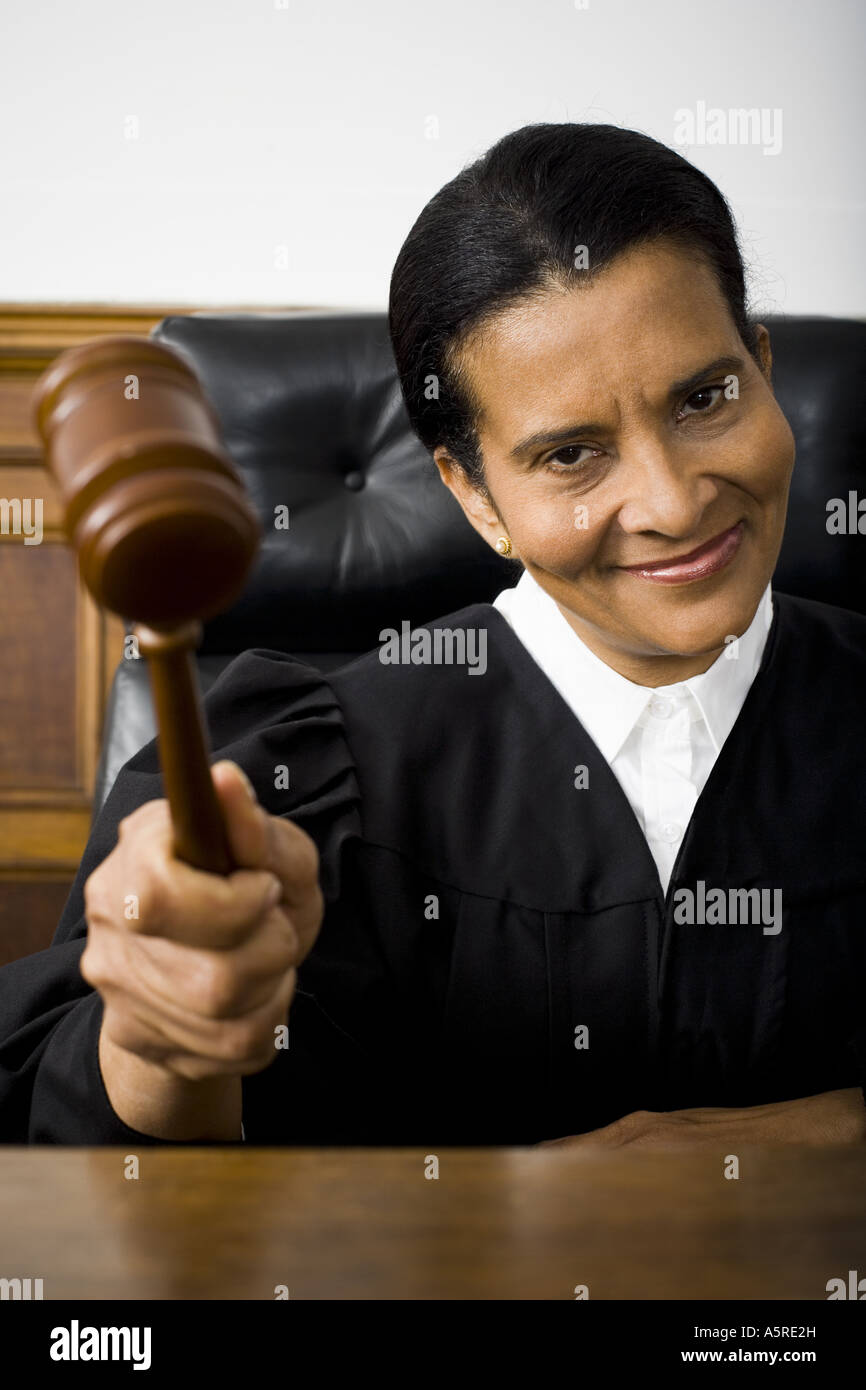 Portrait of a female judge holding a gavel and smiling Stock Photo