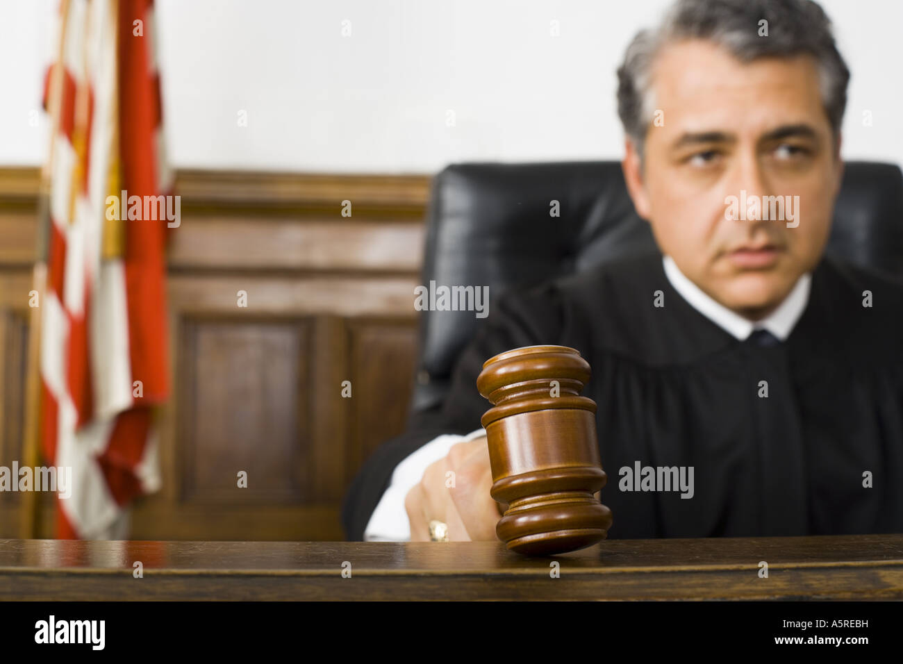 A male judge hitting a gavel on the bench Stock Photo Alamy