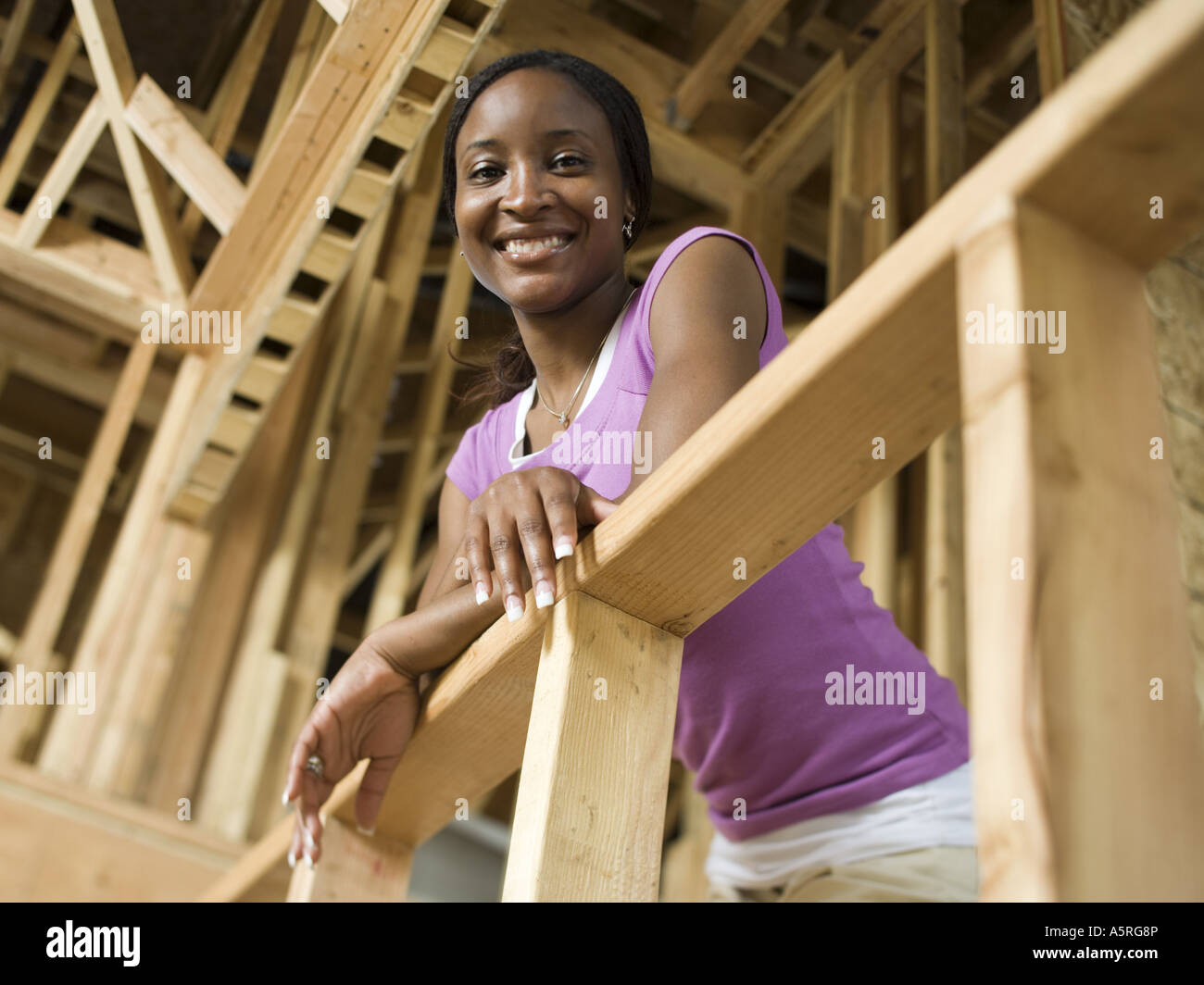 Slumped Against Railing Portrait of a young woman leaning against a railing and smiling Stock ...
