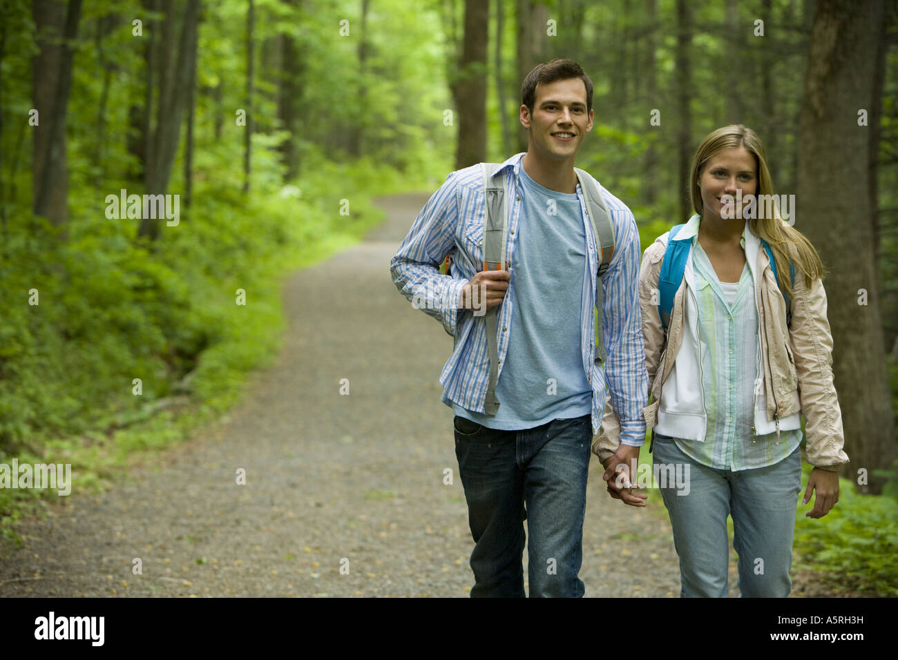 Close up of a young couple walking and holding hands Stock Photo - Alamy