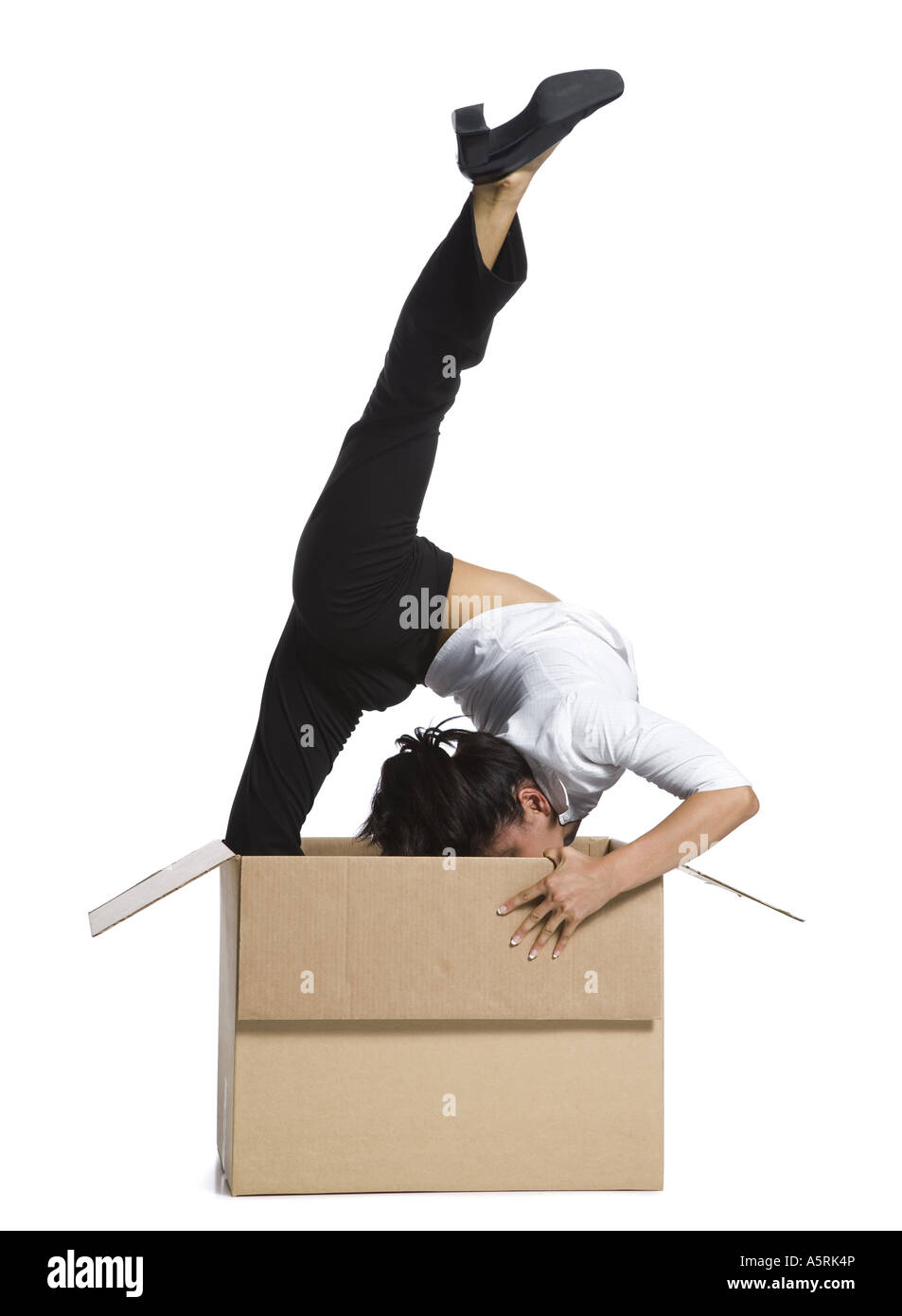 Female contortionist businesswoman inside cardboard box Stock Photo