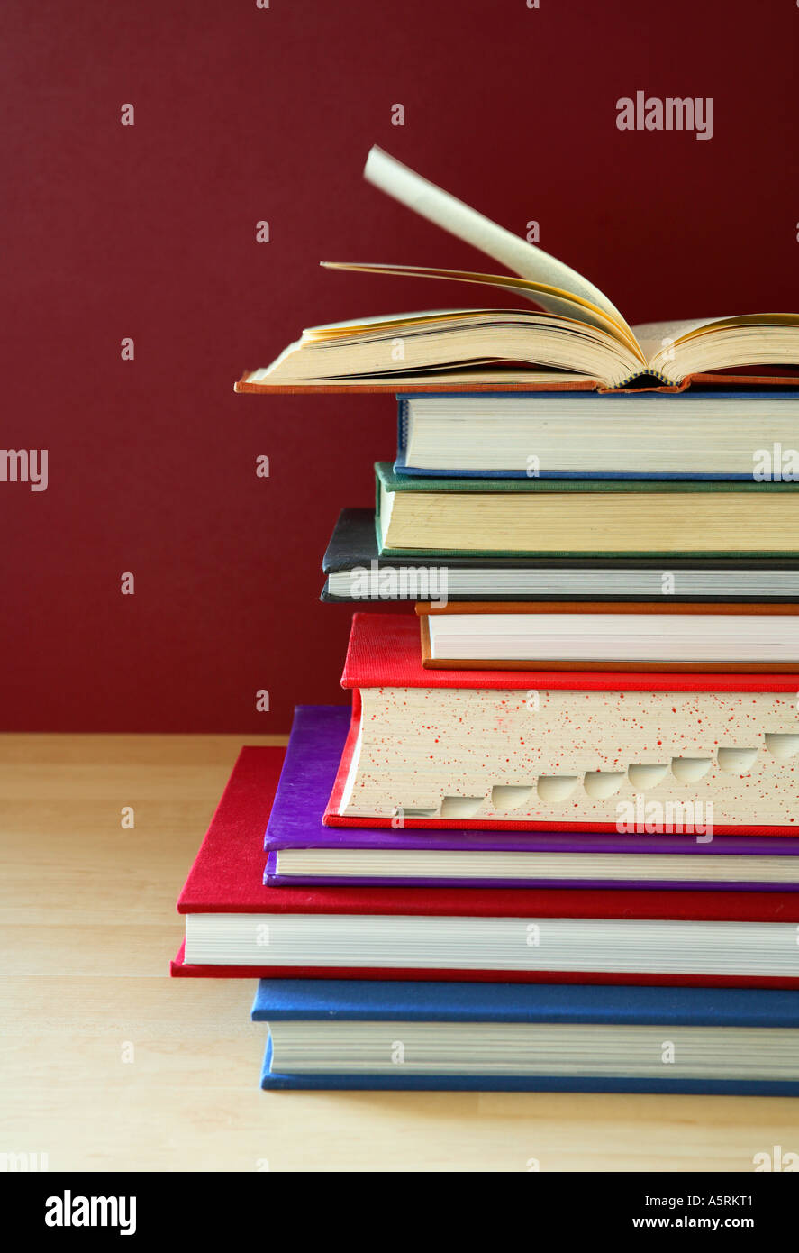 Stack of school books with top book open. Stock Photo
