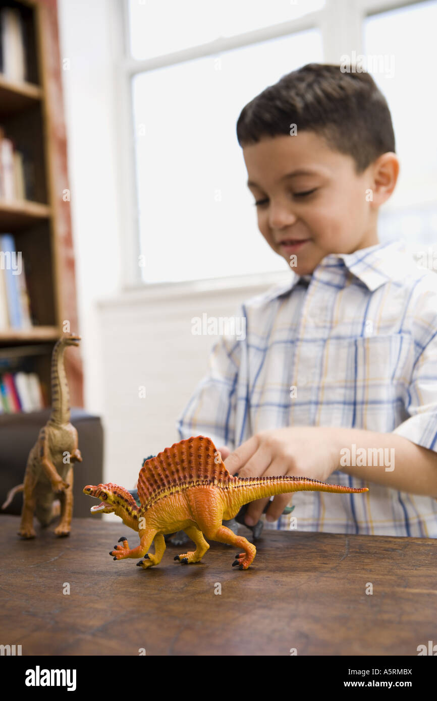 Young boy playing with toy dinosaur figures Stock Photo