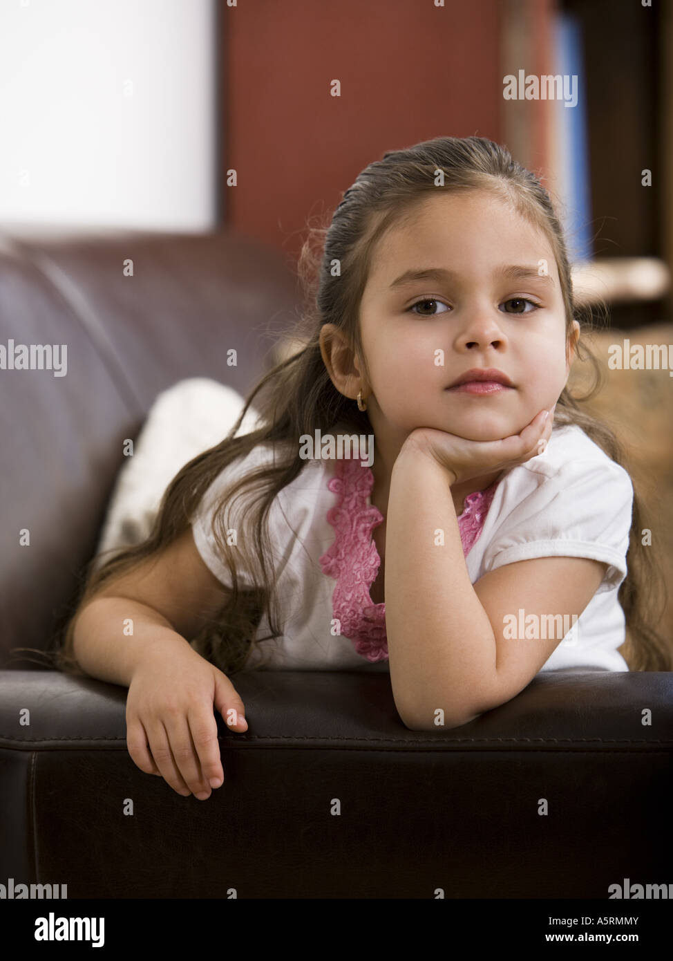 Young girl sitting on leather sofa Stock Photo - Alamy