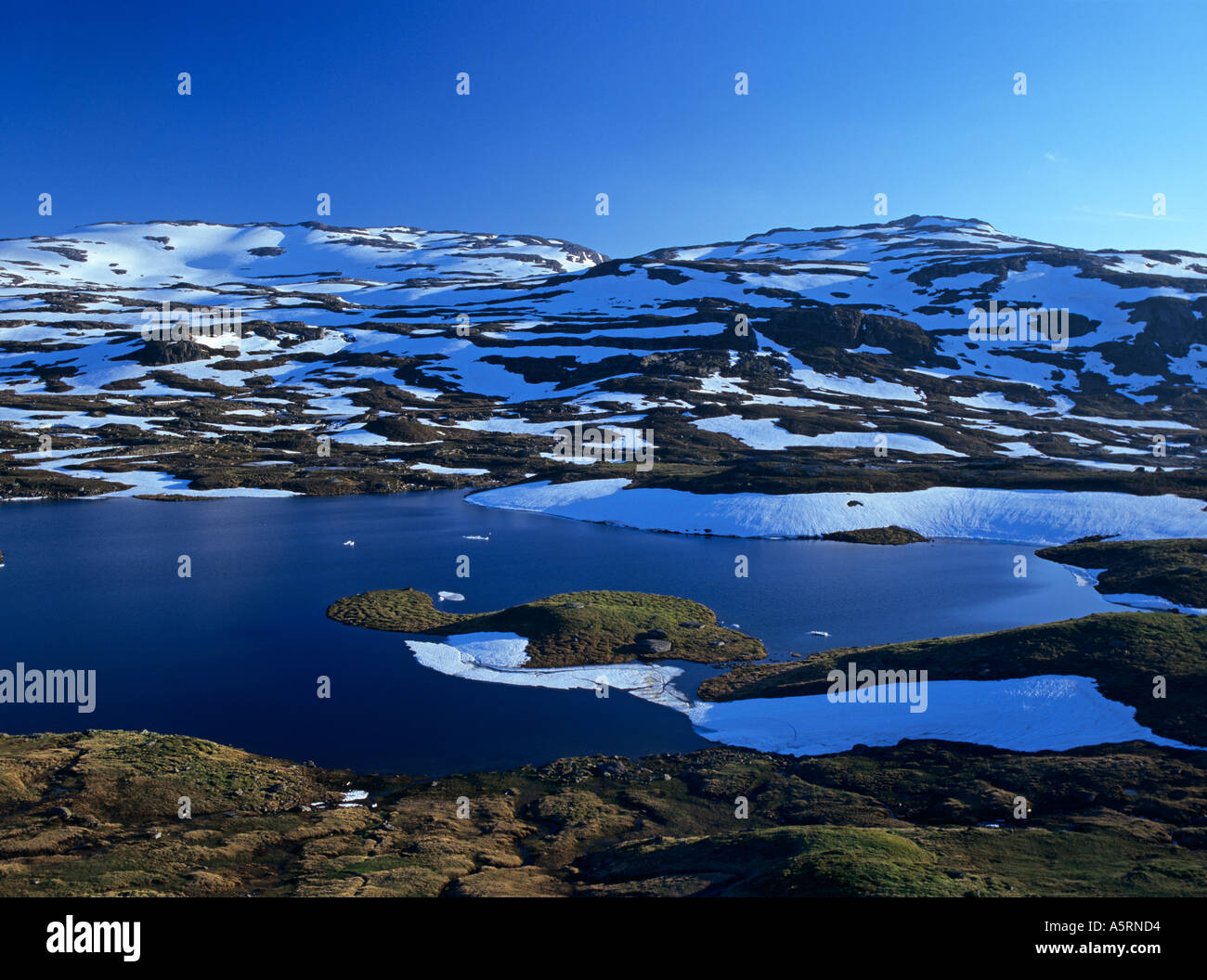 a lake and snow covered mountains on the Haukelifjell Norway Stock Photo