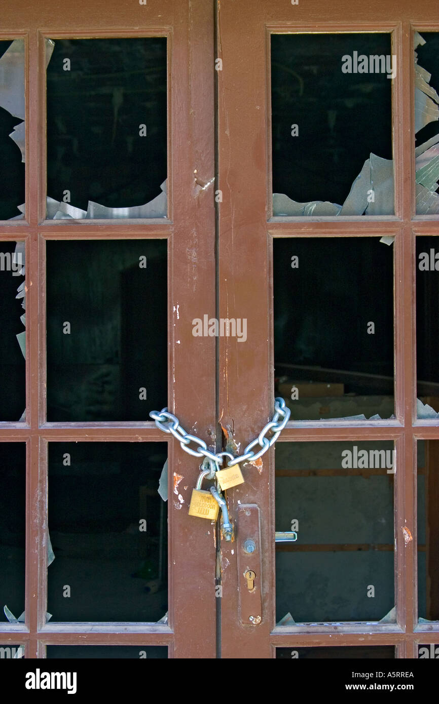 Chain and lock on door with smashed glass Stock Photo