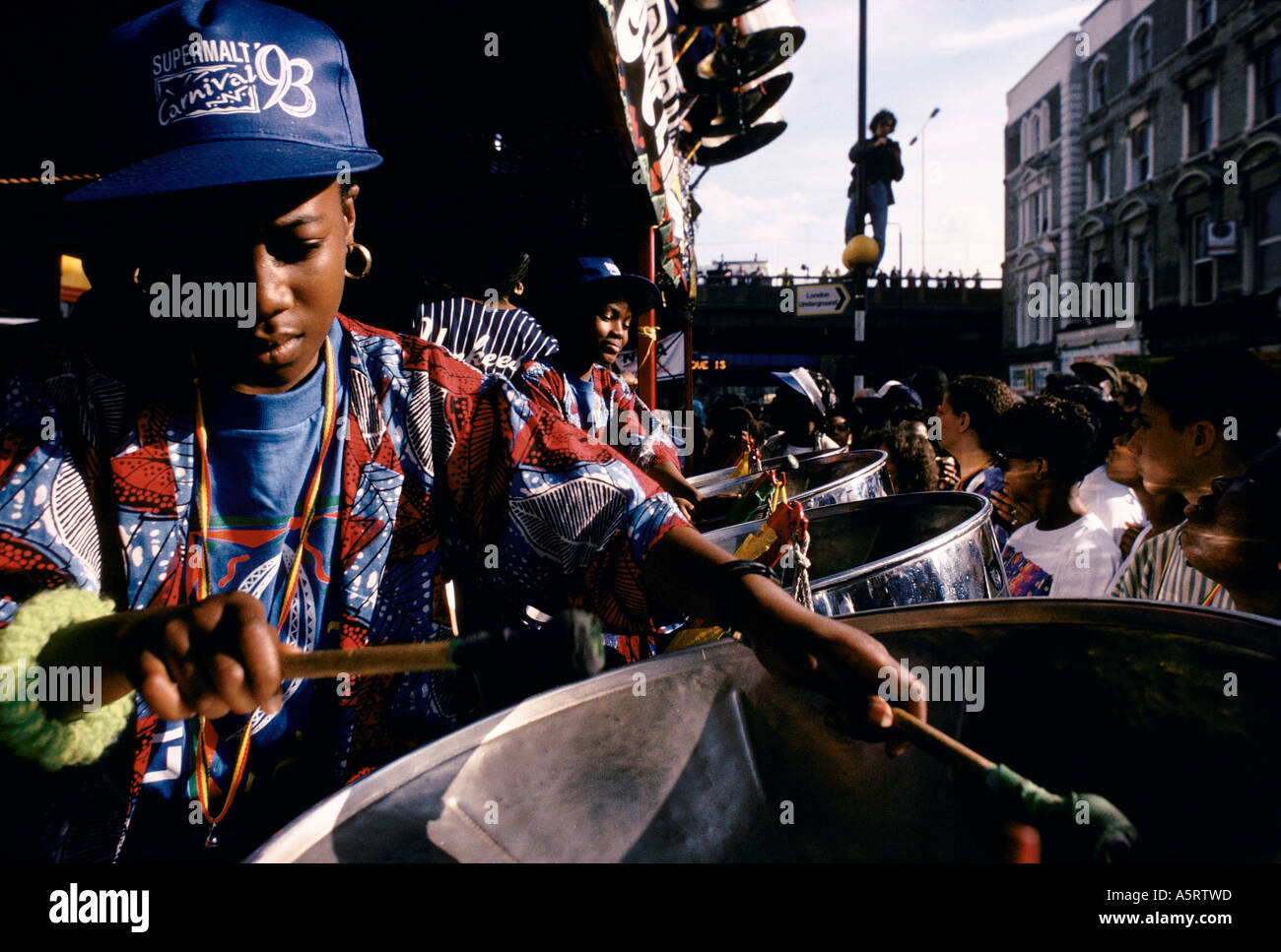 NOTTING HILL CARNIVAL LONDON AUGUST CROWDS WATCHING STEEL BAND PLAYING OFF THE BACK OF A LORRY ALONG THE ROUTE OF THE STREET Stock Photo