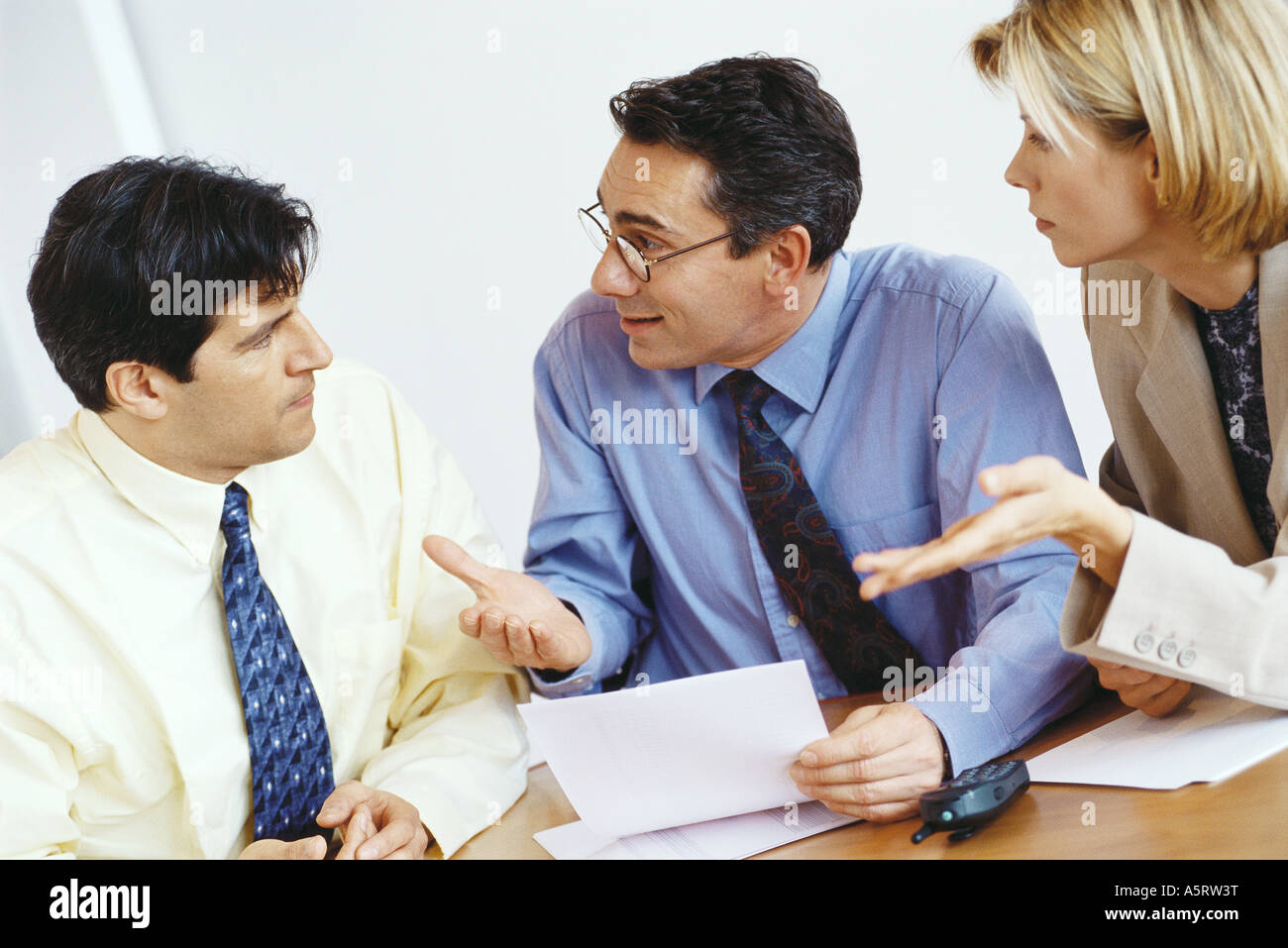 Business colleagues questioning associate Stock Photo