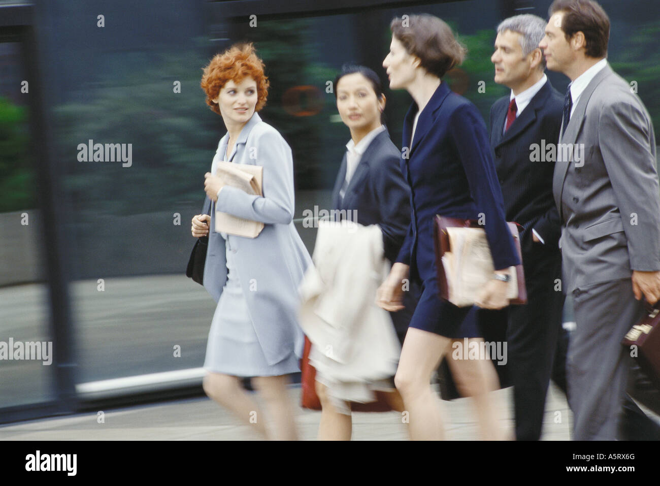 Group of business executives walking, blurred motion Stock Photo - Alamy