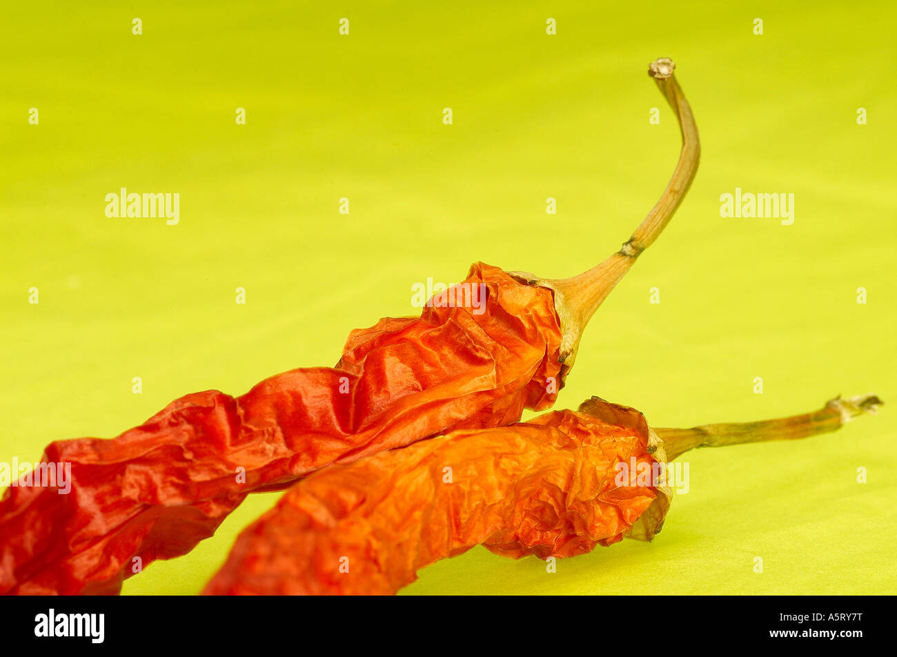 Red hot chili peppers on green background Stock Photo - Alamy