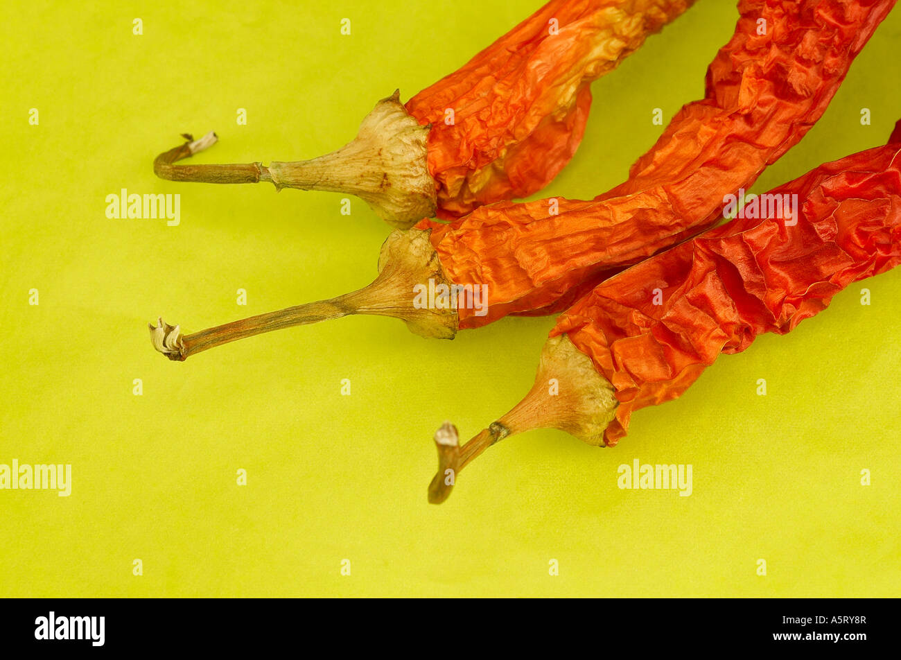 Red hot chili peppers on green background Stock Photo - Alamy