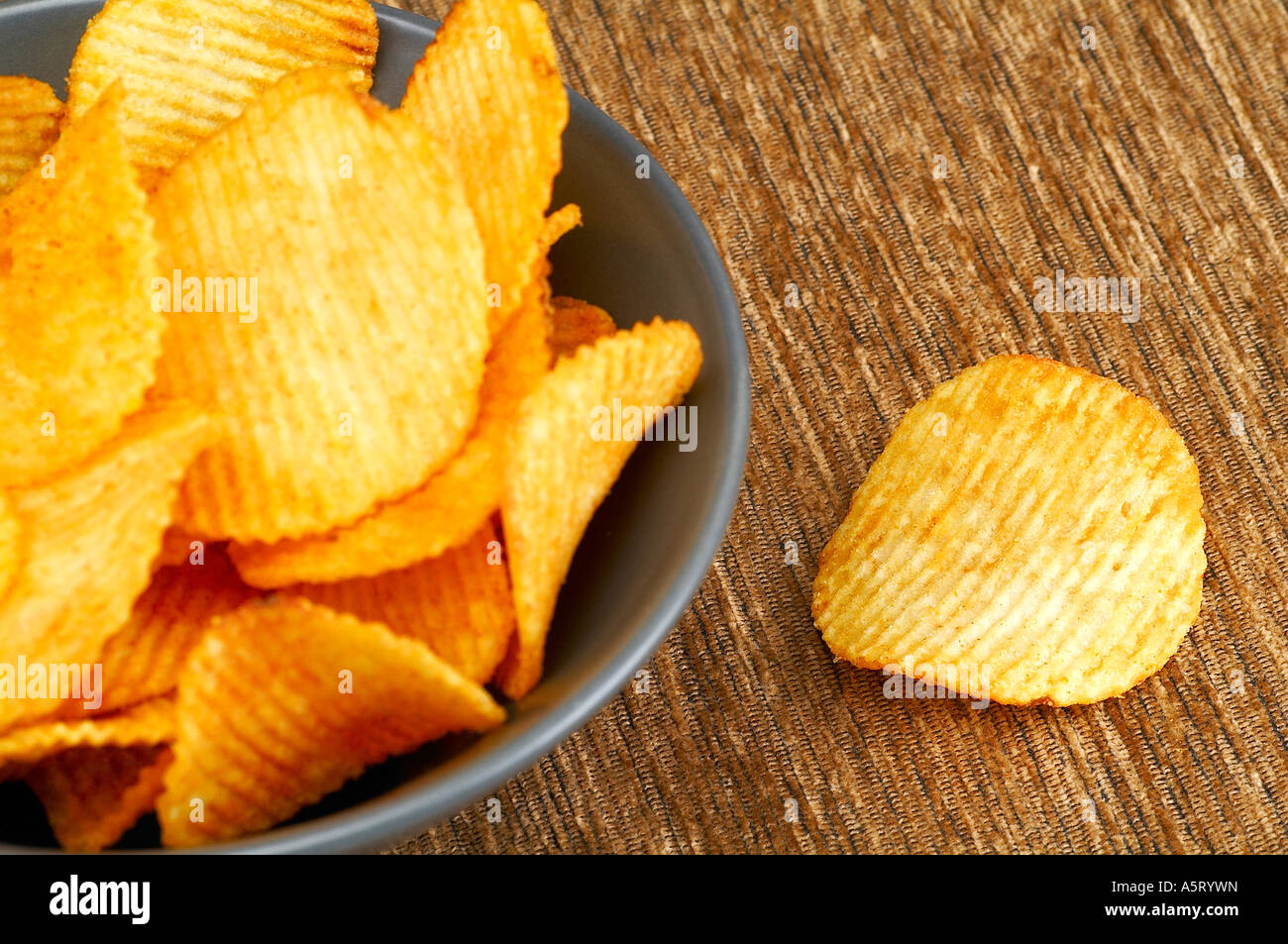 Bowl of crisps on brown cloth Stock Photo Alamy