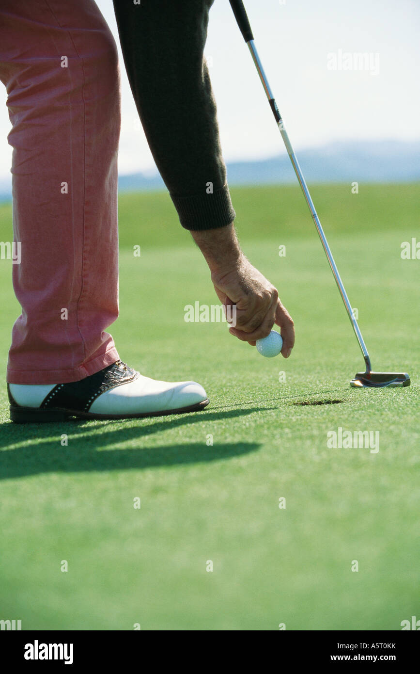 Golfer picking up golf ball, low section Stock Photo Alamy