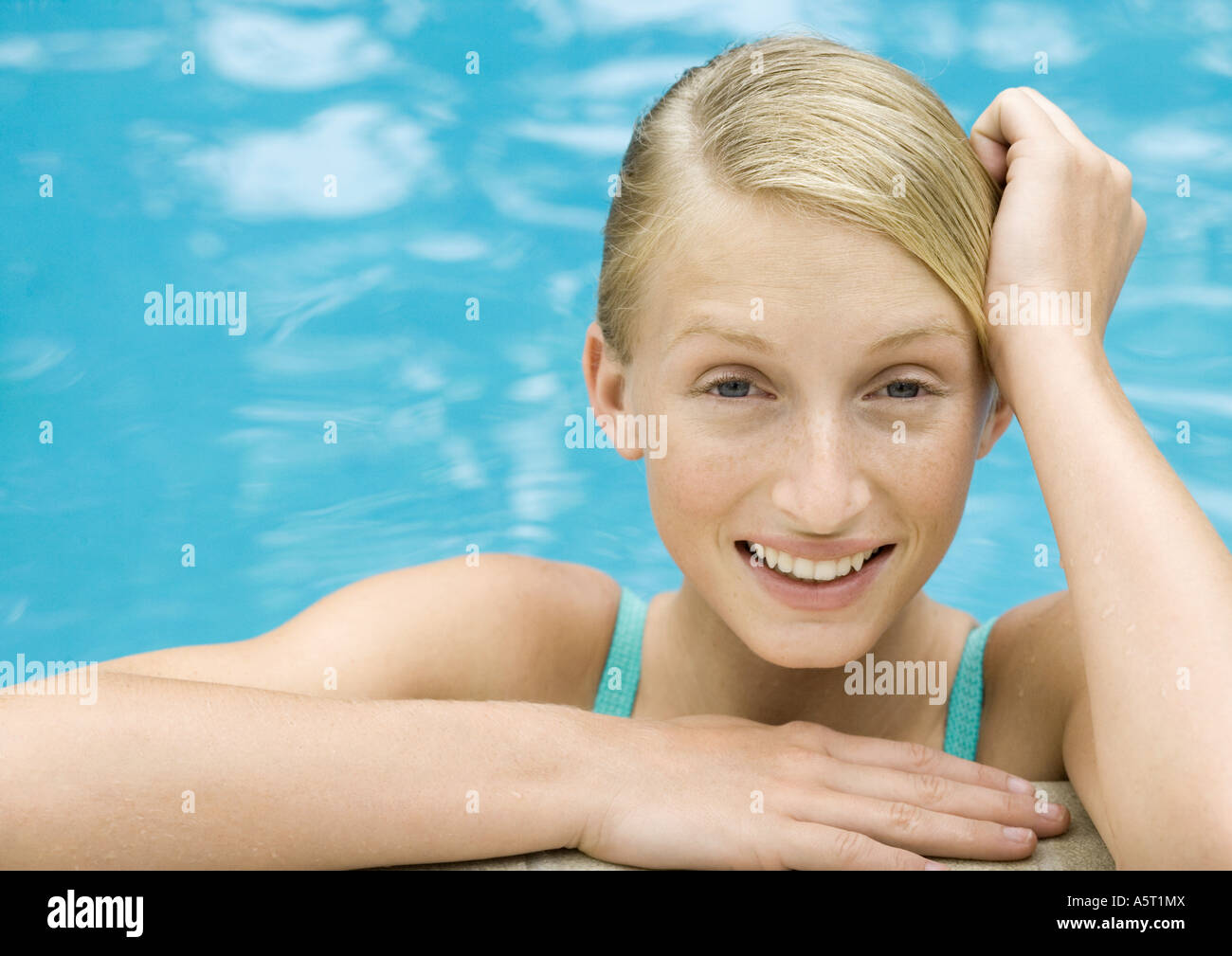 Young woman smiling, portrait, pool water in background Stock Photo