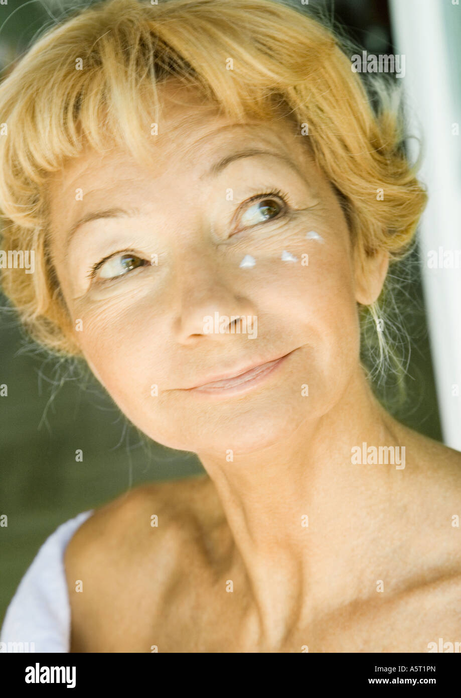 Senior woman with moisturizer under eye Stock Photo Alamy