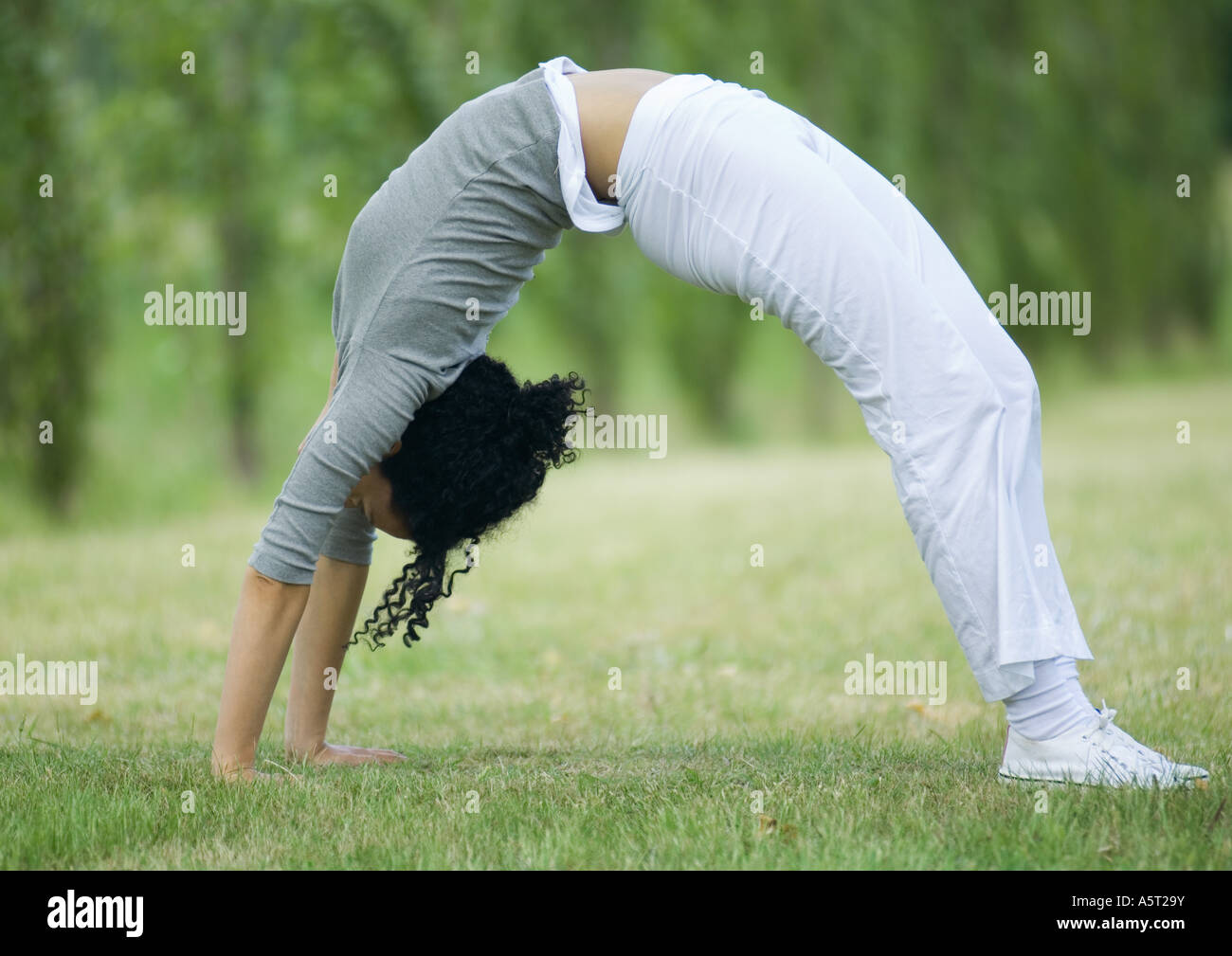 Young woman doing bridge on grass Stock Photo