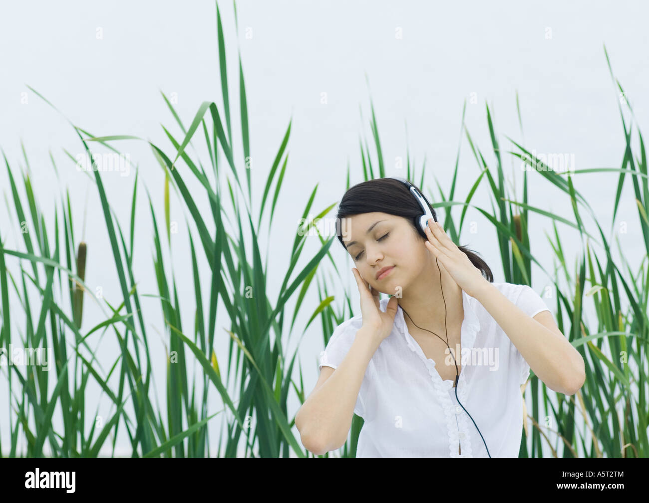 Woman listening to headphones, eyes closed Stock Photo