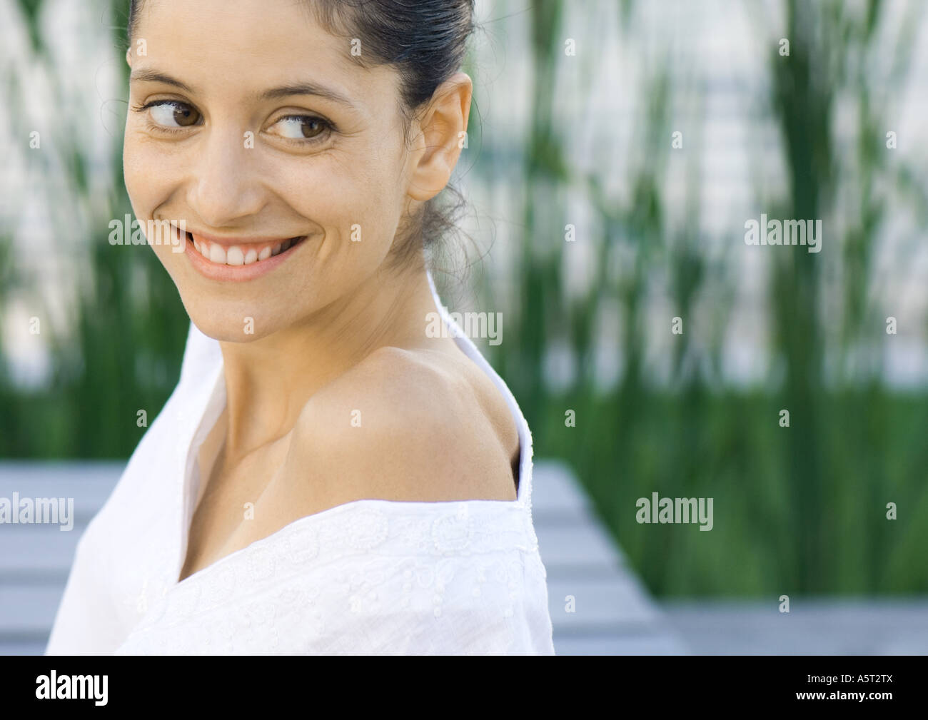 Woman smiling, looking over shoulder Stock Photo