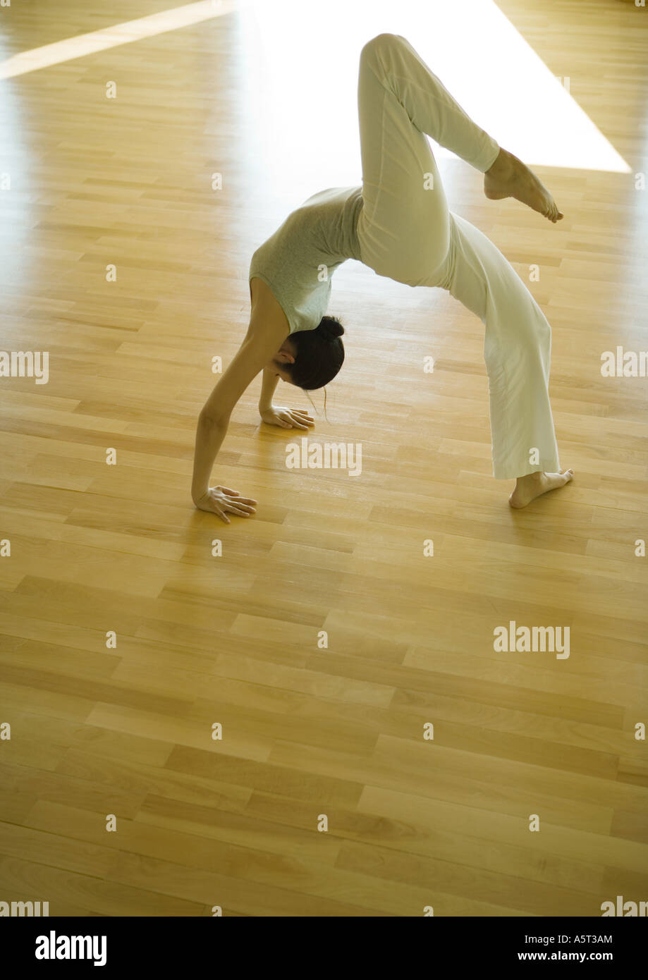Yoga class, woman doing one-legged bridge pose Stock Photo