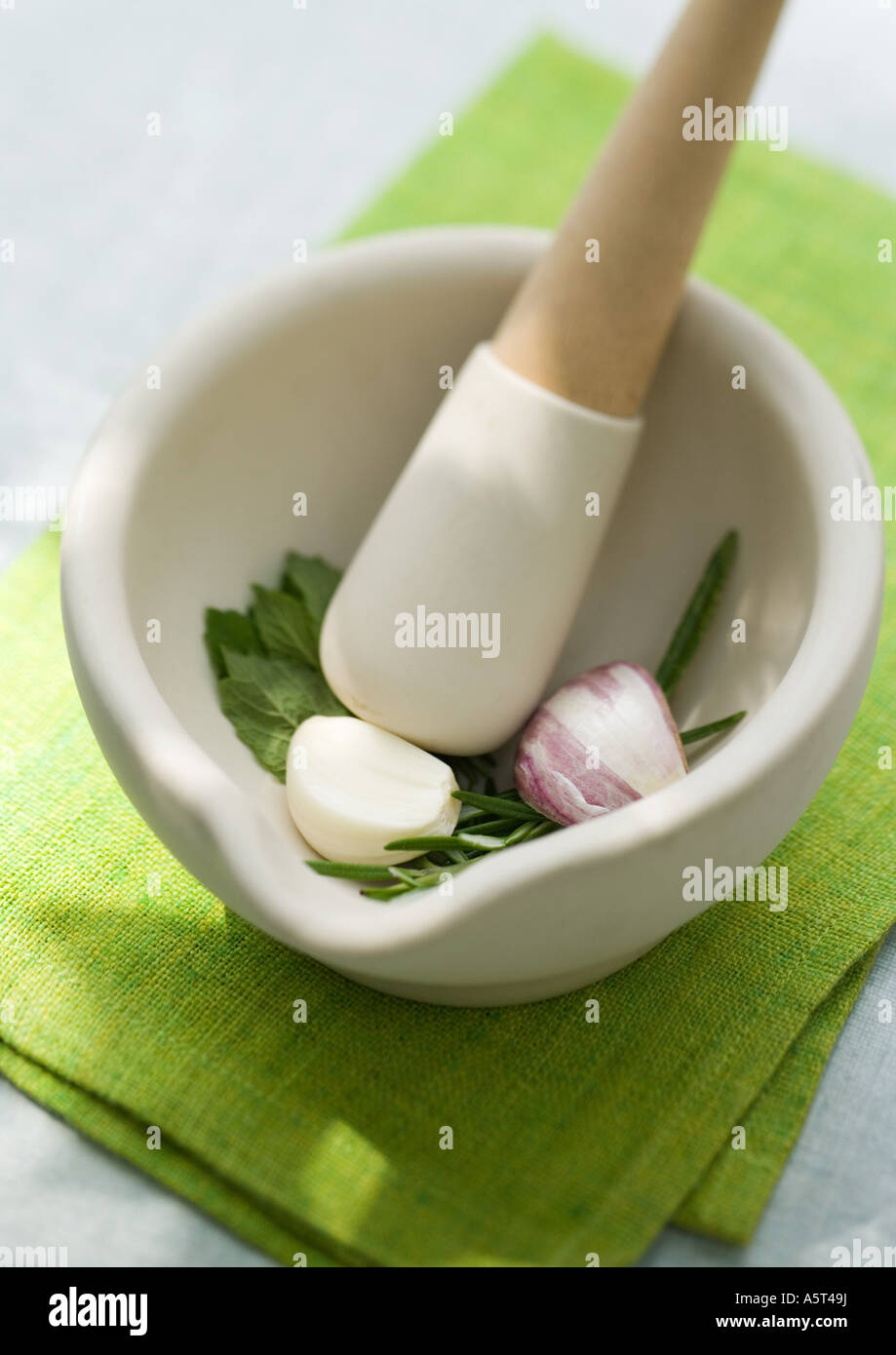 Mortar and pestle with herbs and garlic Stock Photo