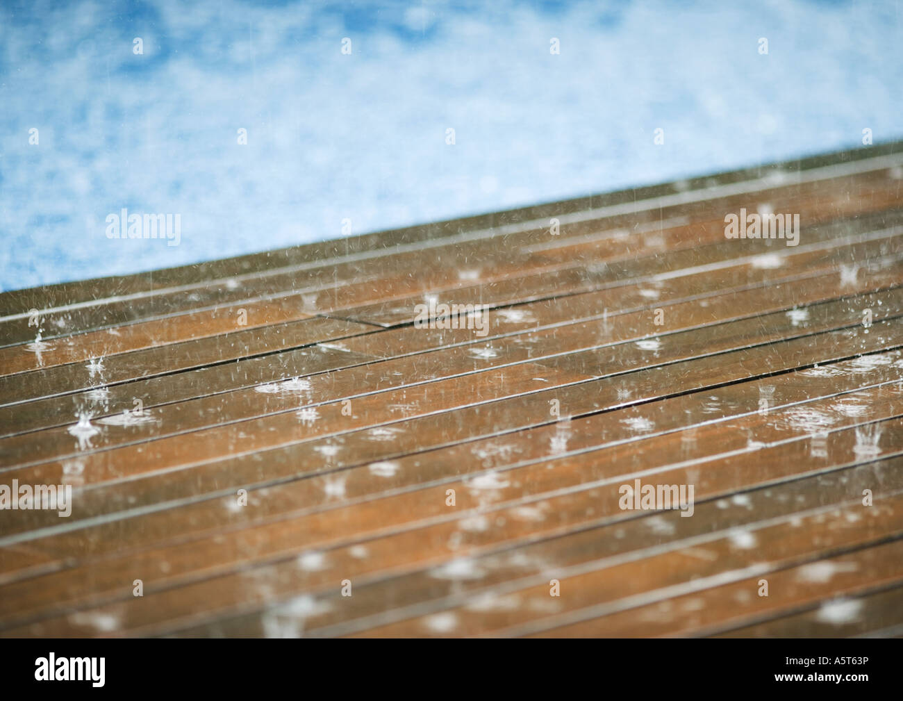 Rain falling on pool decking Stock Photo