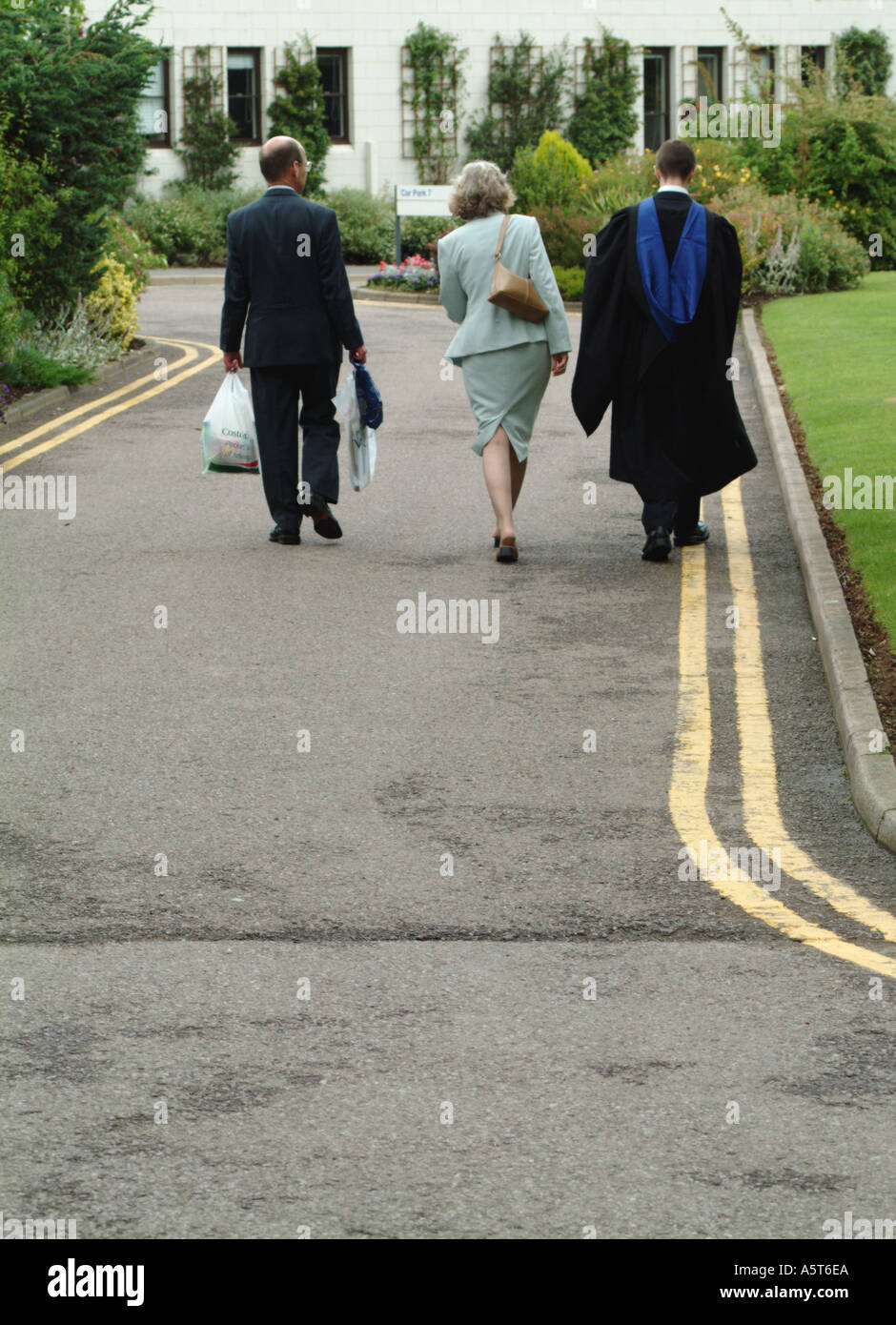 new graduate leaves after graduation ceremony with his parents Stock Photo