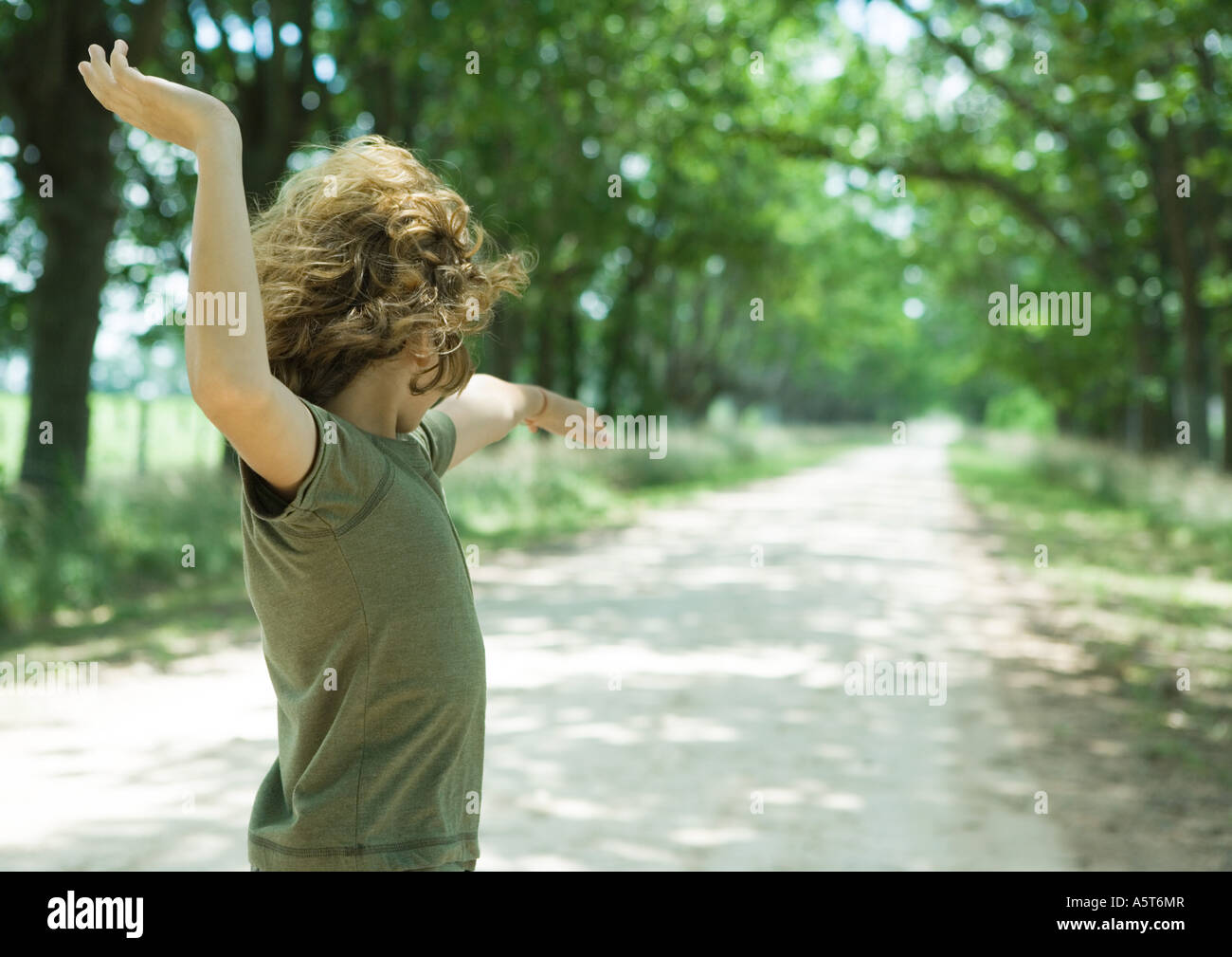 Boy playing in middle of dirt road Stock Photo - Alamy