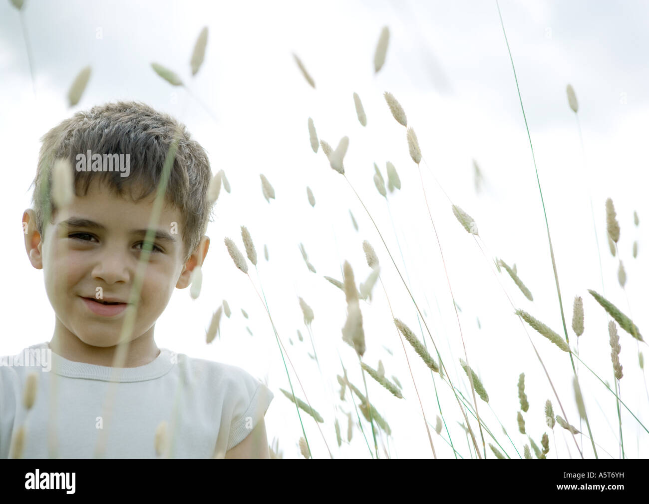 Boy standing in weeds Stock Photo - Alamy