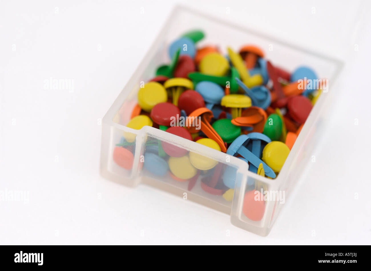 Container full of coloured brads (paper fasteners) used in papercrafts