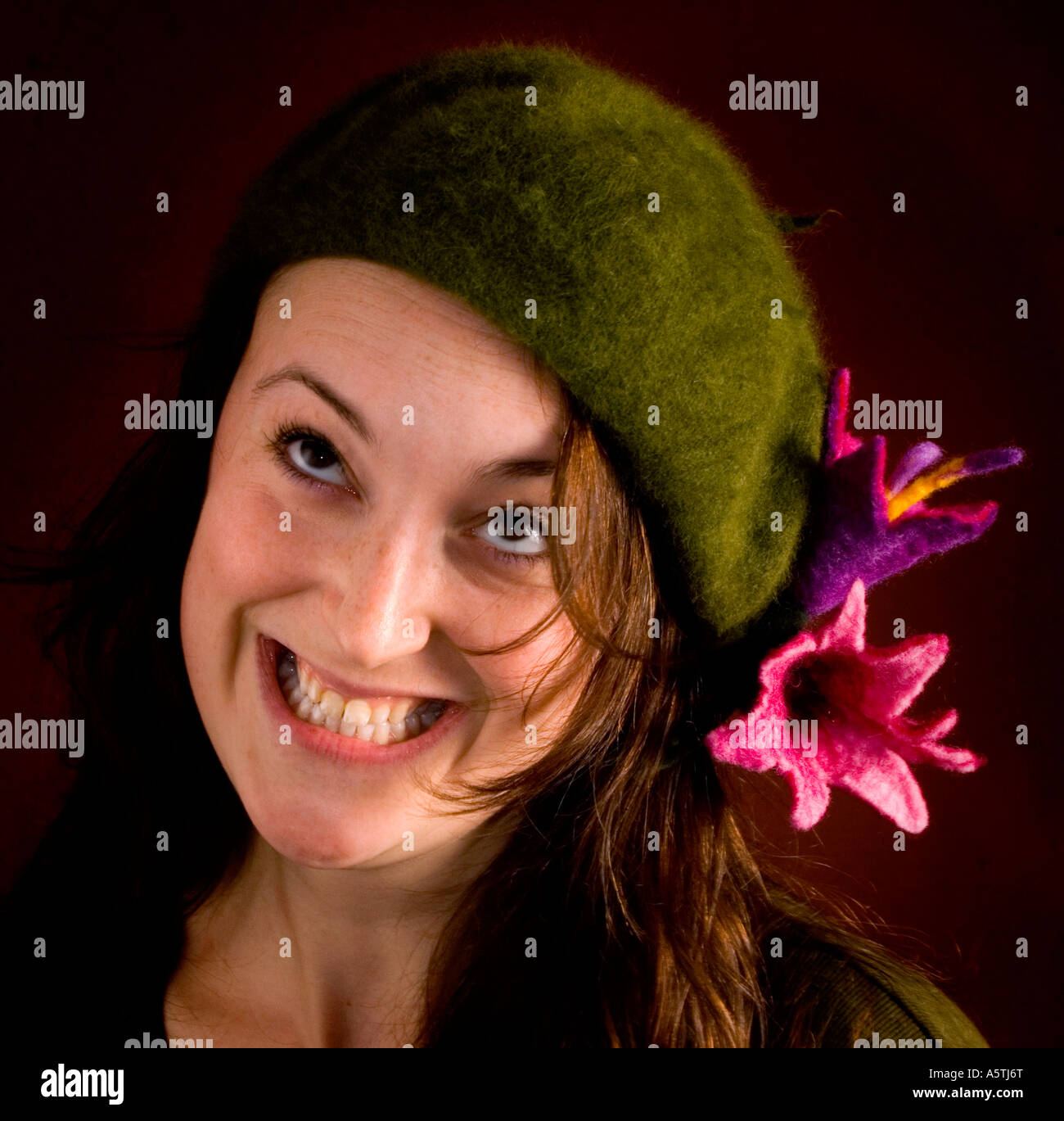 A happy smiling young woman wearing felt flowers on her hat. Picture by Jim Holden. Stock Photo