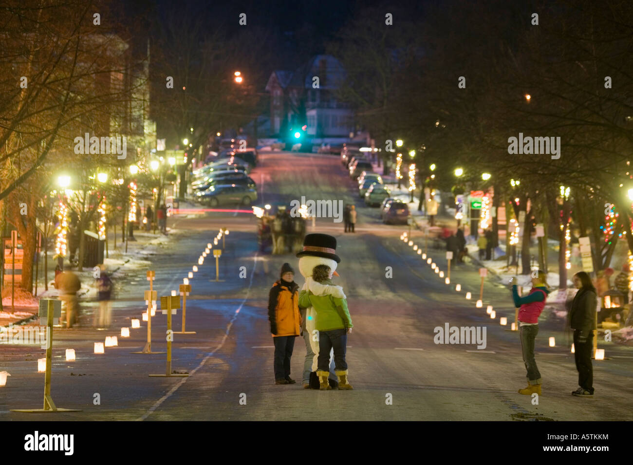 Candlelight stroll Christmas time Cooperstown New York luminaries on Main Street and snowman Stock Photo