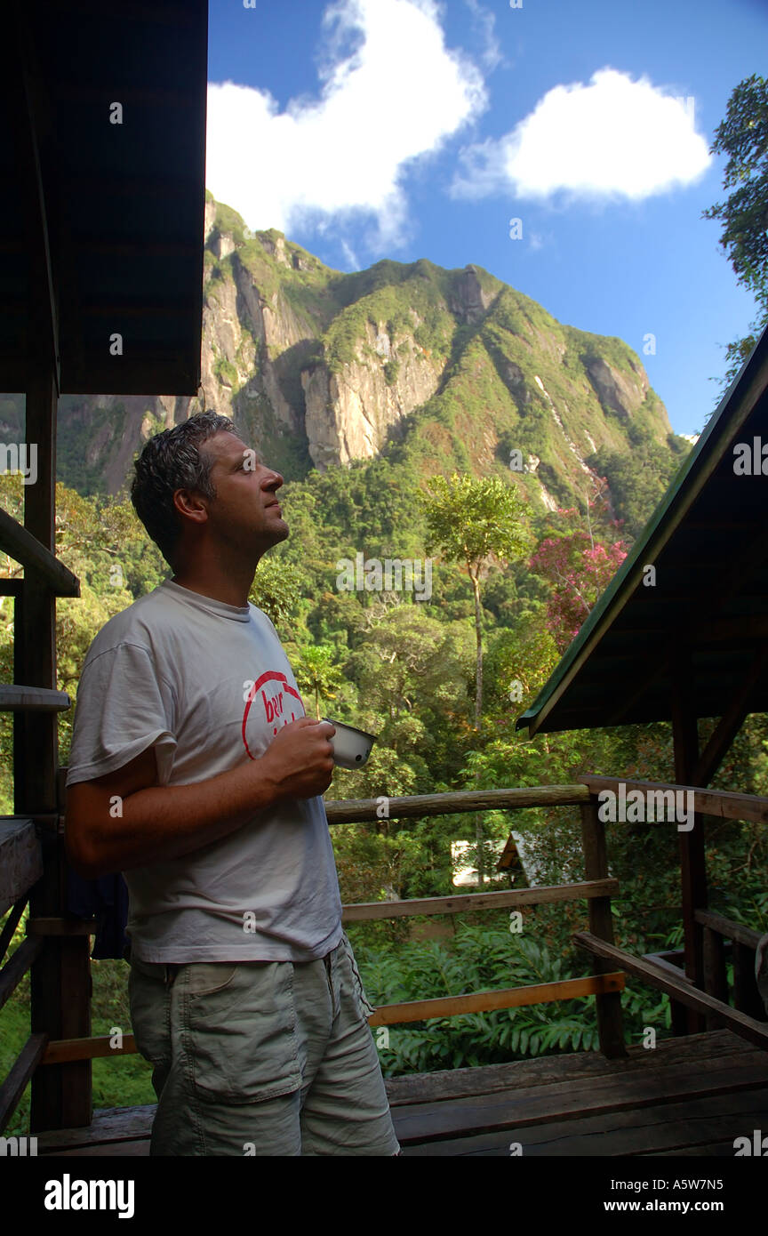 Ecotourist enjoying spectacular morning views from Camp II Marojejy National Park Madagascar MR Stock Photo