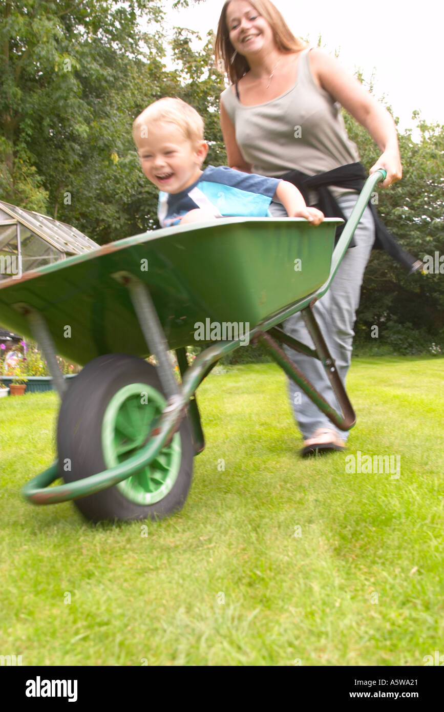 young boy sitting in wheelbarrow Stock Photo - Alamy