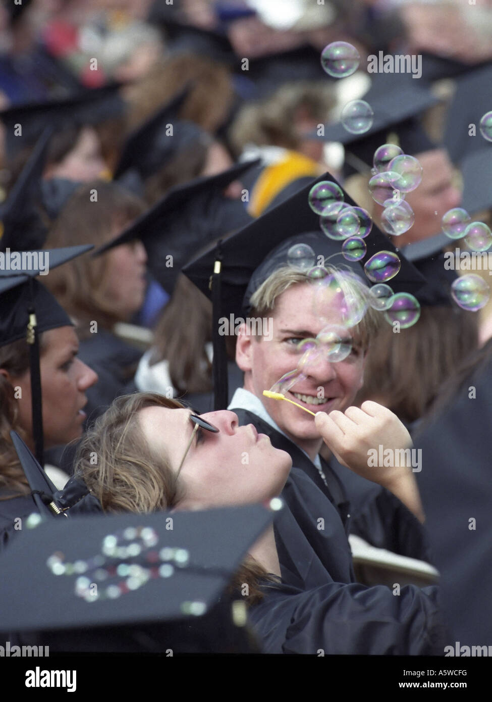 Graduate blows bubbles during a College Graduation ceremony Southern Connecticut State University Hamden Connecticut 1998 Stock Photo