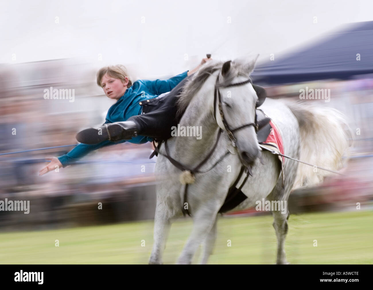 Boy in Cossack costume showing off his horsemanship at country show Stock Photo