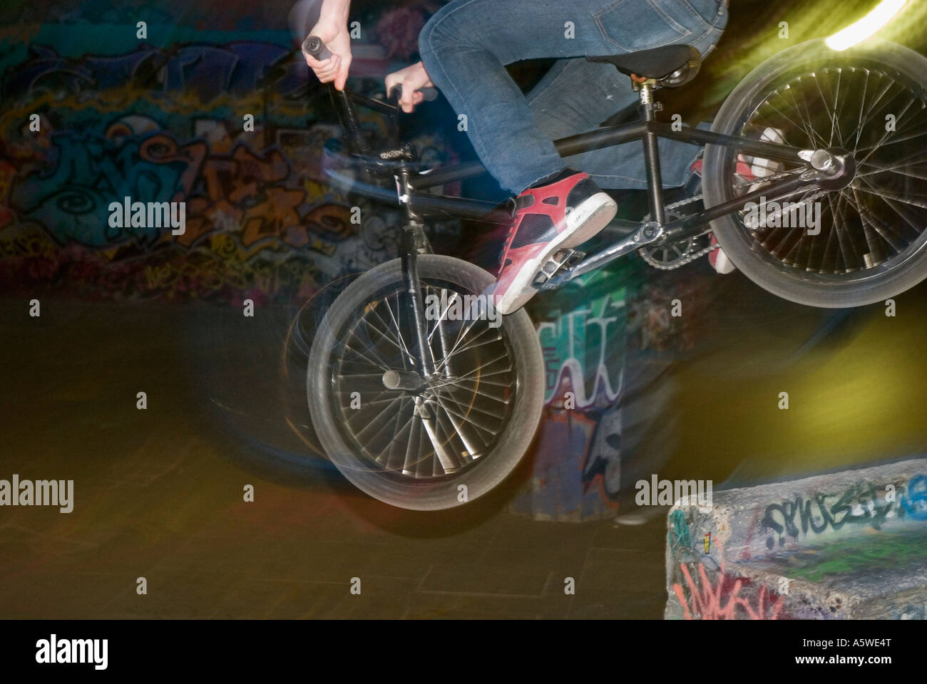 BMX bike in mid-air in urban setting with graffiti filled walls Stock ...