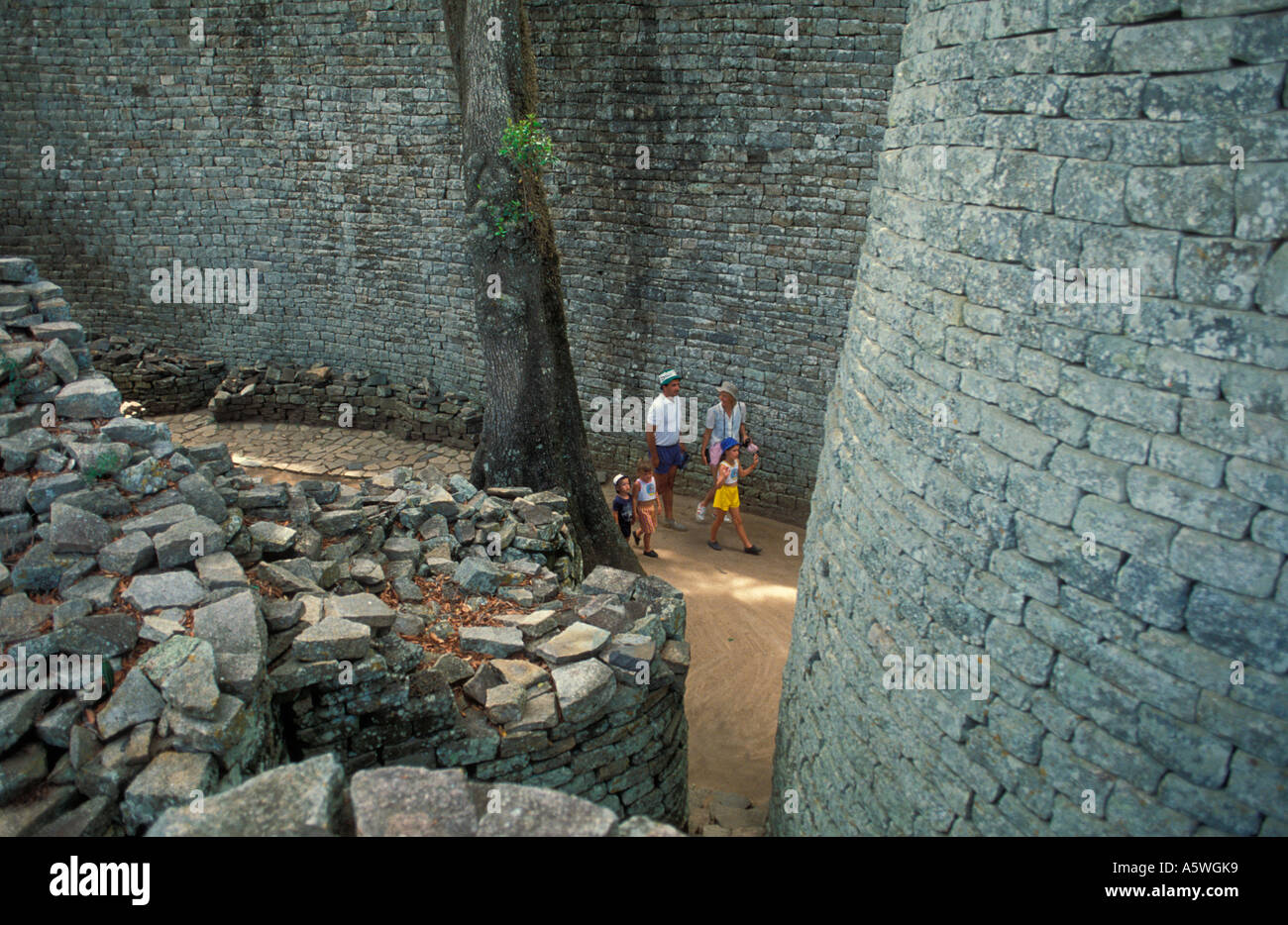 View of Tourists walking around the Great Enclosure near the Conical Tower at Great Zimbabwe National Monument, Zimbabwe, Africa Stock Photo