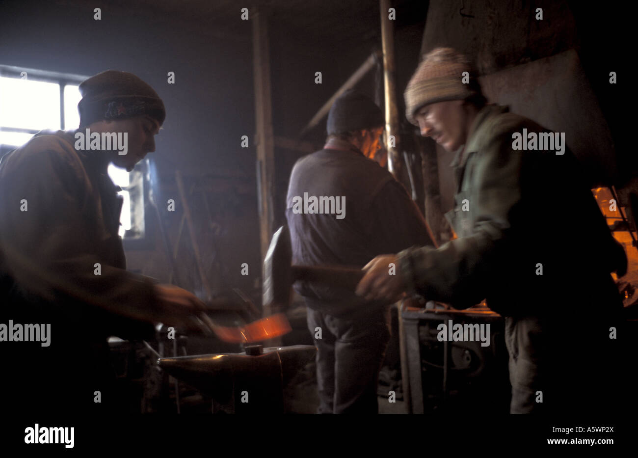 Blacksmiths in the Szekely Hungrian minority area of Transylvania Romania repairing a sledge at their forge Stock Photo
