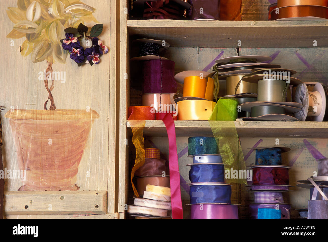 OLD CUPBOARD FULL OF DECORATIVE RIBBONS IN FLORAL STUDIO. Stock Photo