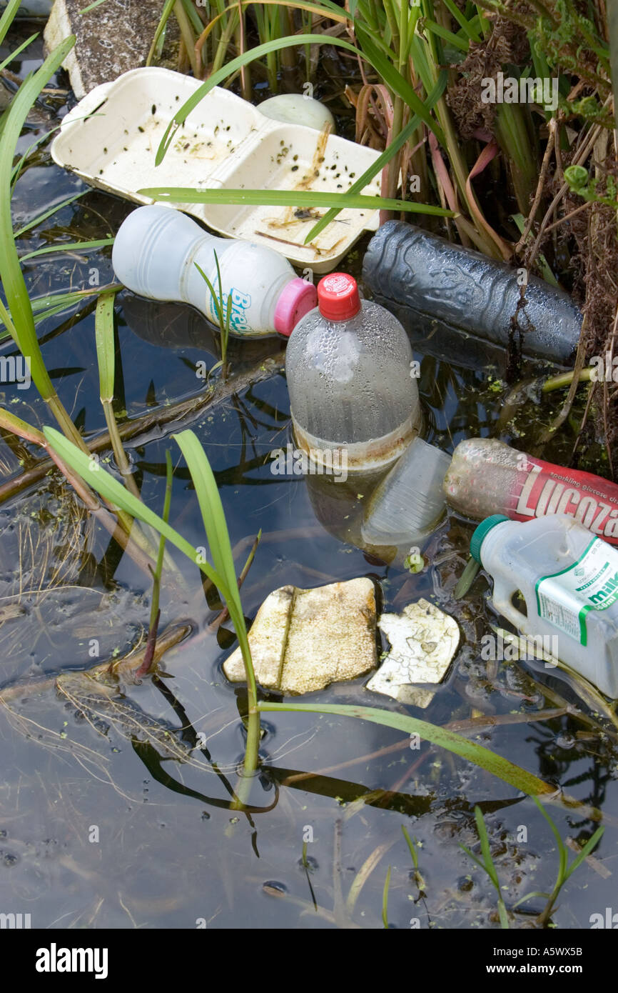 Plastic bottles rubbish, fast food packaging, polystyrene food tray rubbish thrown away in canal in radcliffe bury lancashire uk Stock Photo