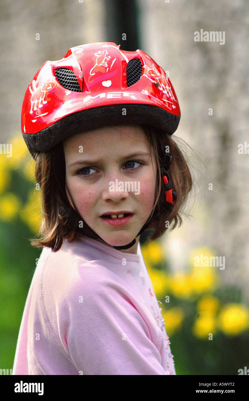 portrait of a young girl on a bike wearing a red safety