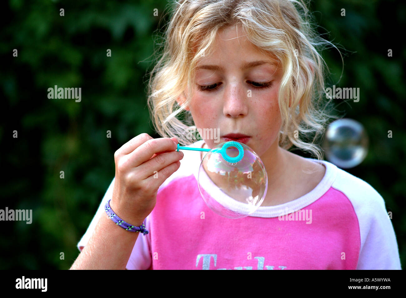 pretty, young girl blowing bubbles outside Stock Photo