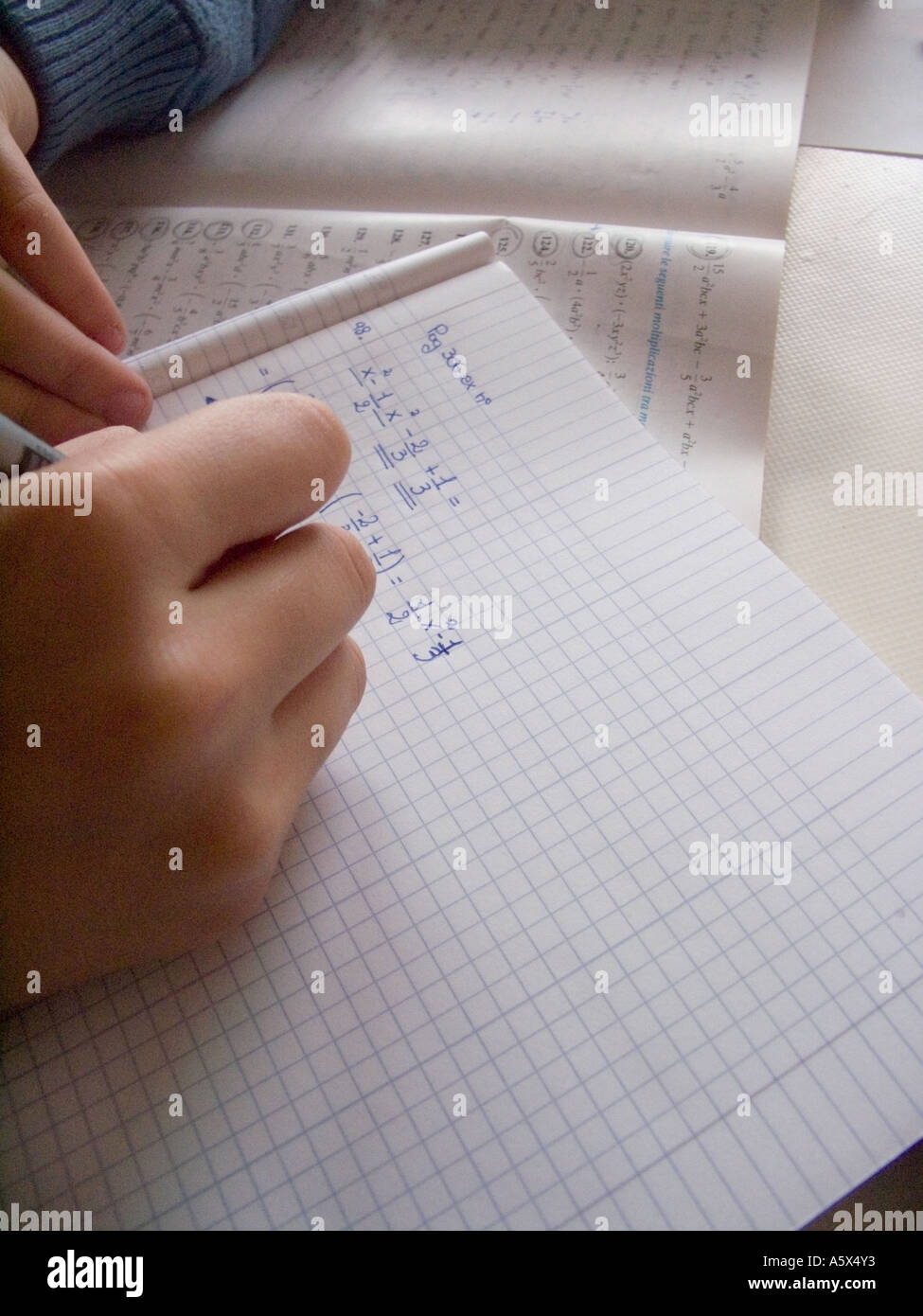 algebra homework - hand of a student writing data math calculation and equation Stock Photo