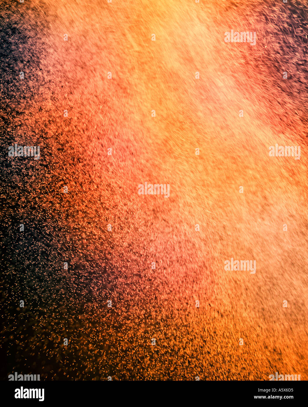 ABSTRACT IMAGE OF RED AND ORANGE PARTICLES SWIRLING IN TURBULENT AIR Stock Photo