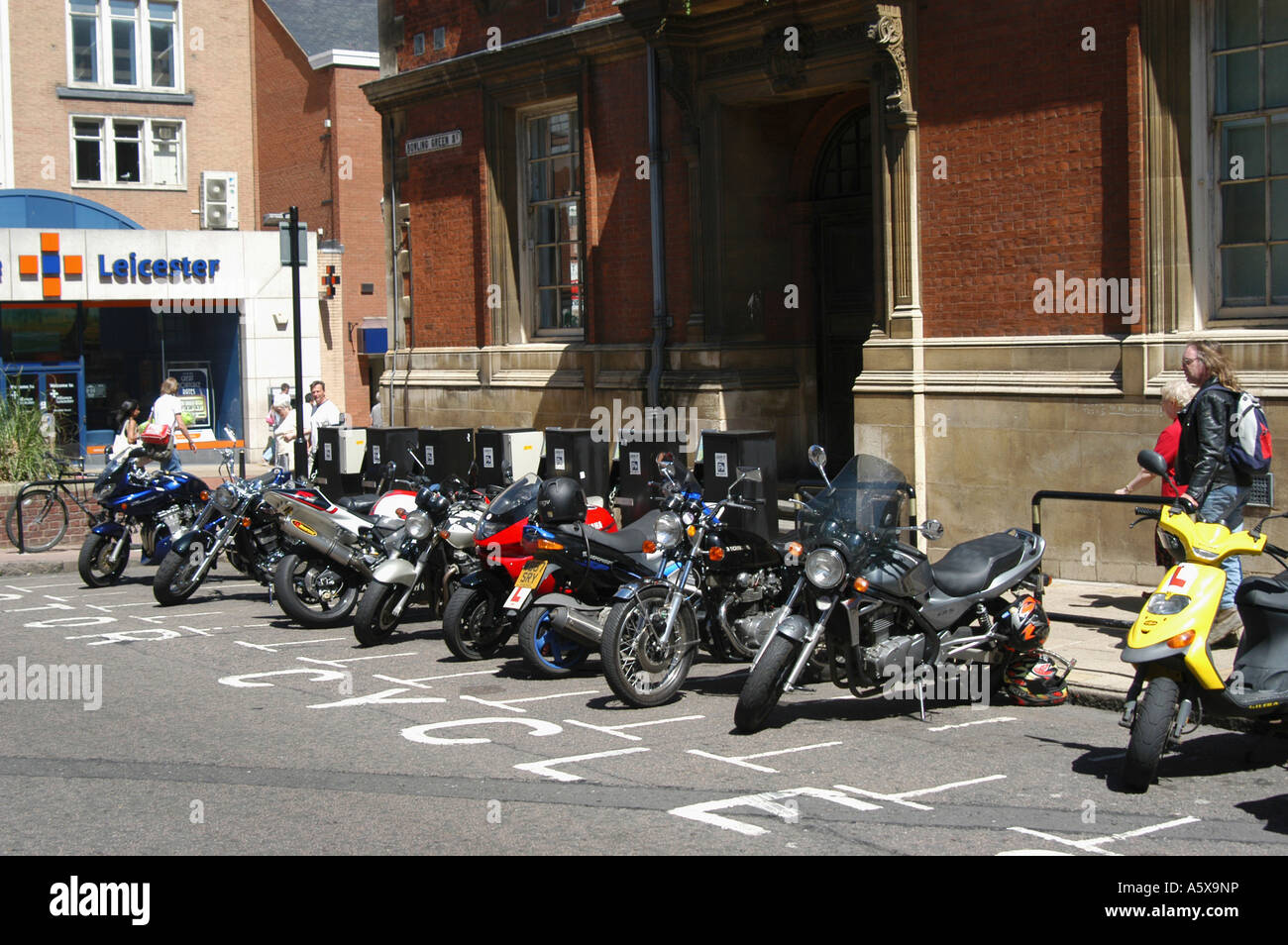 Motorcycles parked in a designated parking area on a city street Stock