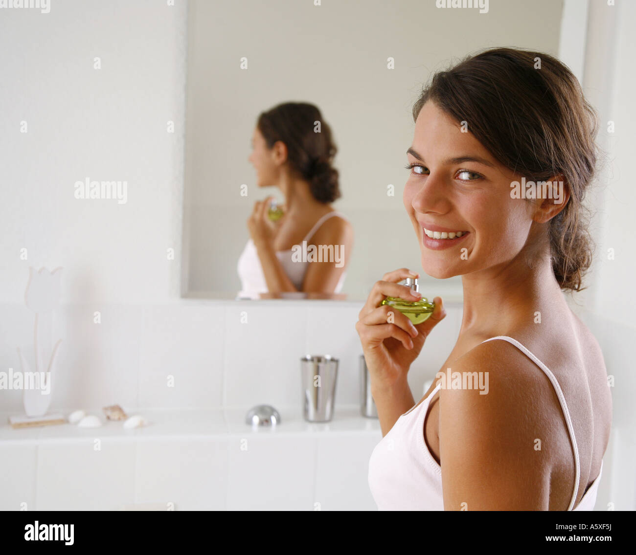Young woman holding perfume bottle close up portrait Stock Photo