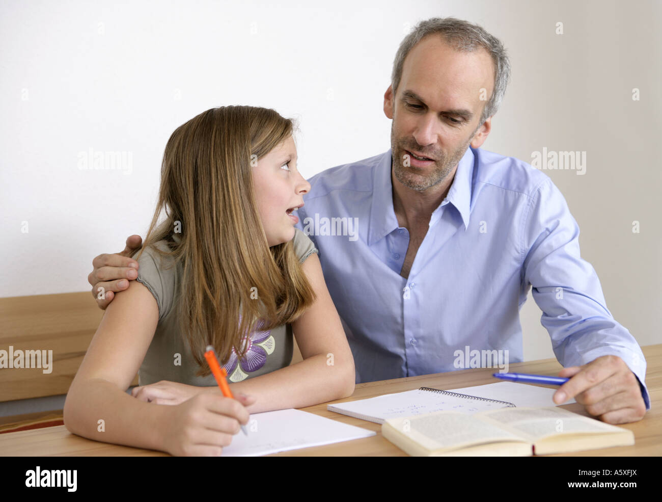 Father taking homework of daughter Stock Photo