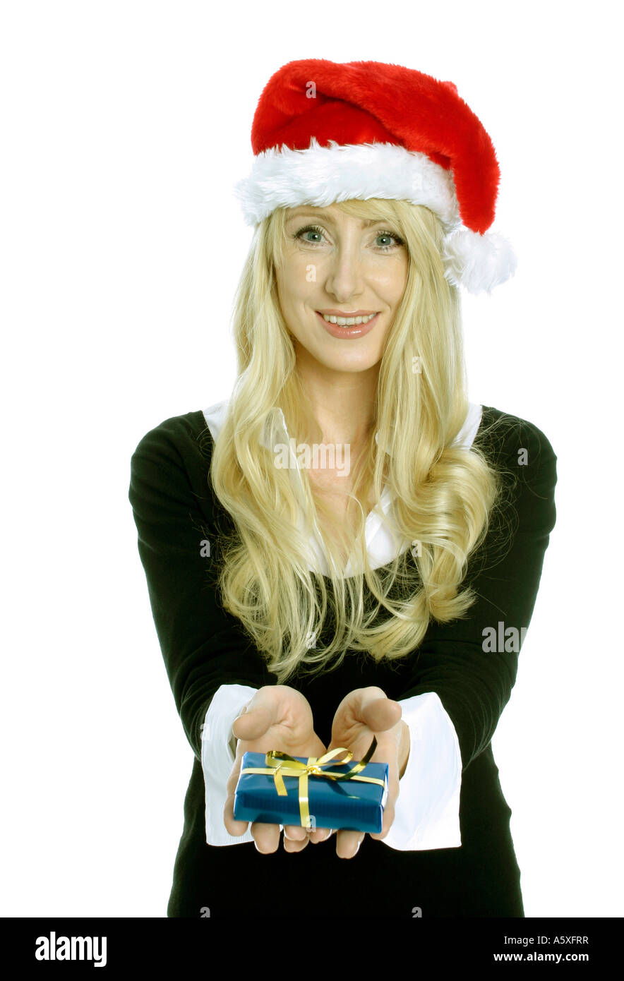 Mid adult woman wearing Santa hat and holding Christmas gift close up portrait Stock Photo