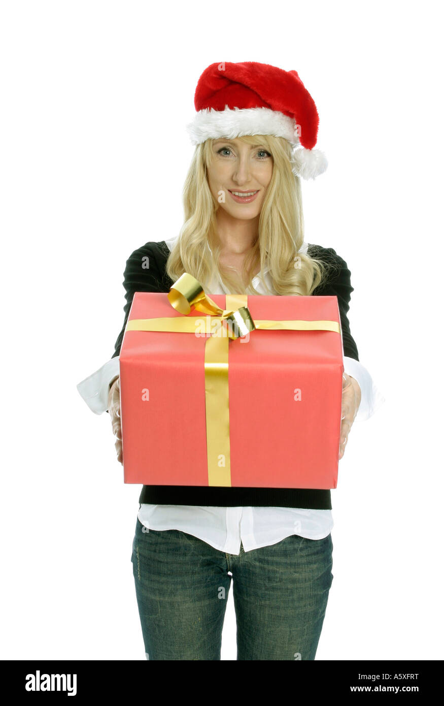 Mid adult woman wearing Santa hat and holding Christmas gift portrait Stock Photo