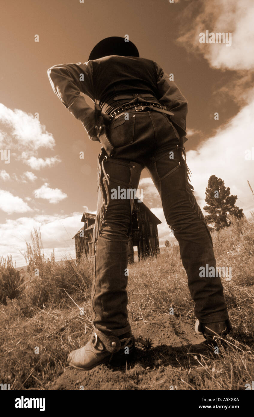 Cowboy with Gun outside an old Log cabin Oregon USA. Sepia toned Stock Photo
